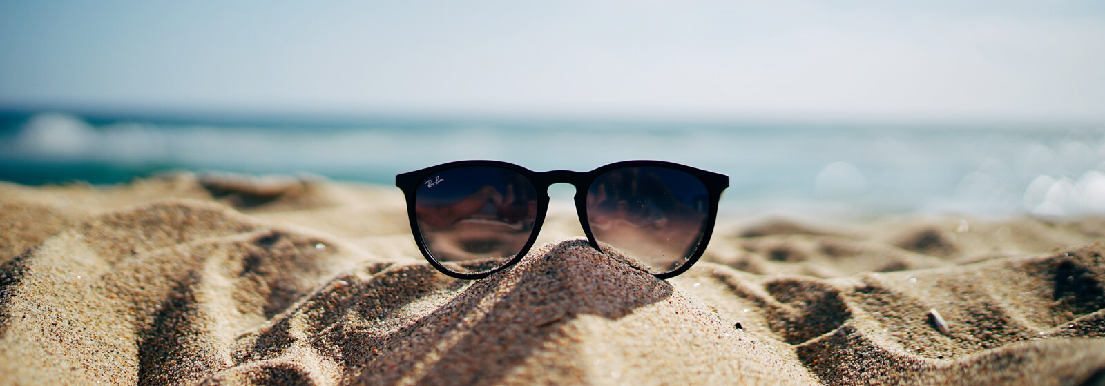Sunglasses in the sand image slide